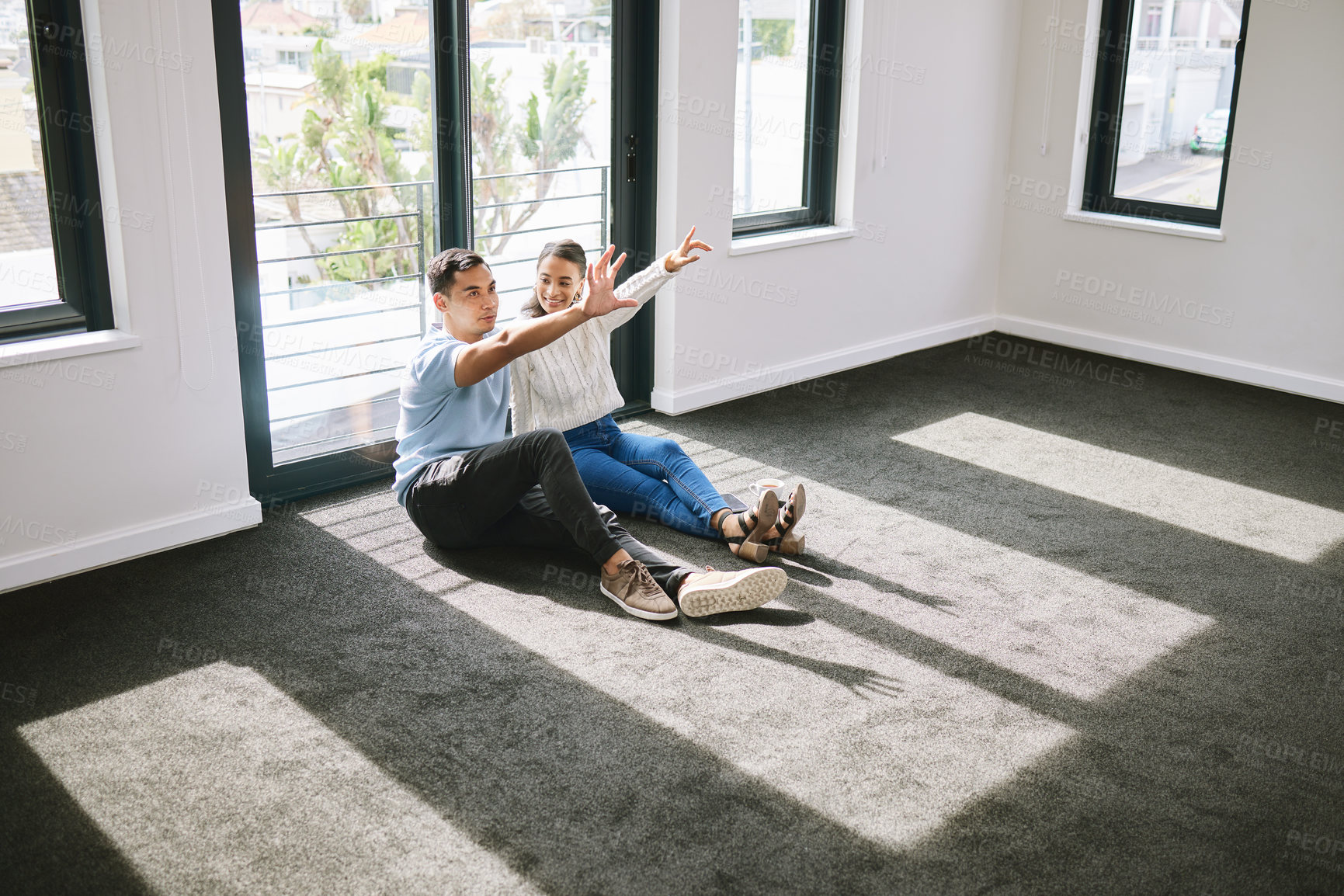 Buy stock photo Full length shot of a young couple sitting together and planning the interior design of their new home