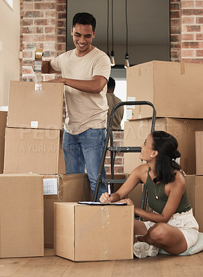 Buy stock photo Shot of a young couple packing up to move in a room at home