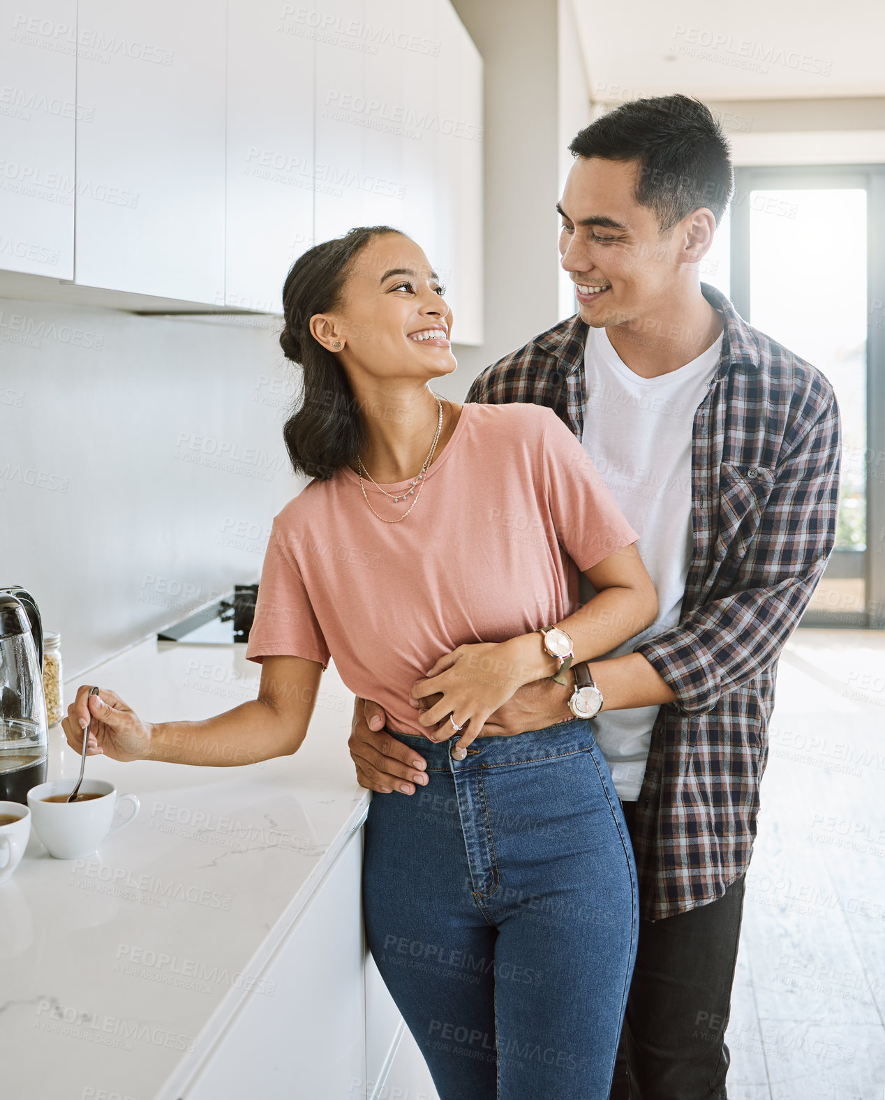 Buy stock photo Shot of a couple spending time together in the kitchen at home