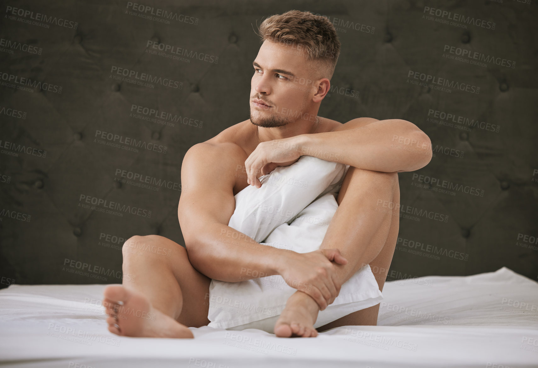 Buy stock photo Full length shot of a handsome and muscular young man looking thoughtful while sitting in his bed at home