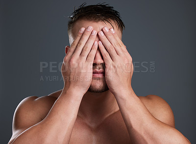 Buy stock photo Studio shot of a handsome and hunky young man posing in studio against a gray background