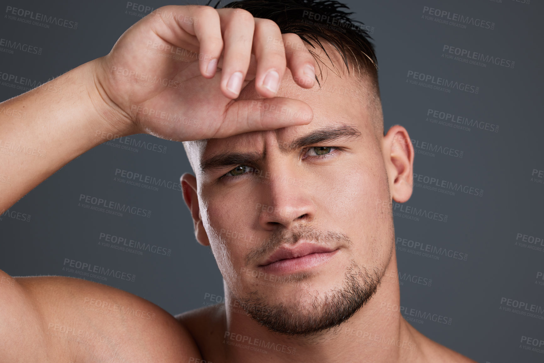 Buy stock photo Studio portrait of a handsome and hunky young man posing in studio against a gray background