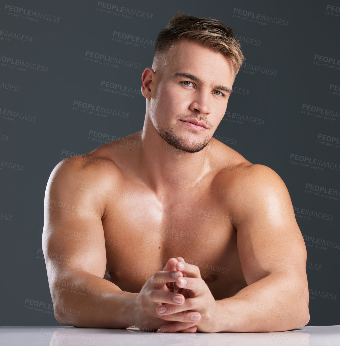 Buy stock photo Studio portrait of a handsome and hunky young man posing in studio against a gray background