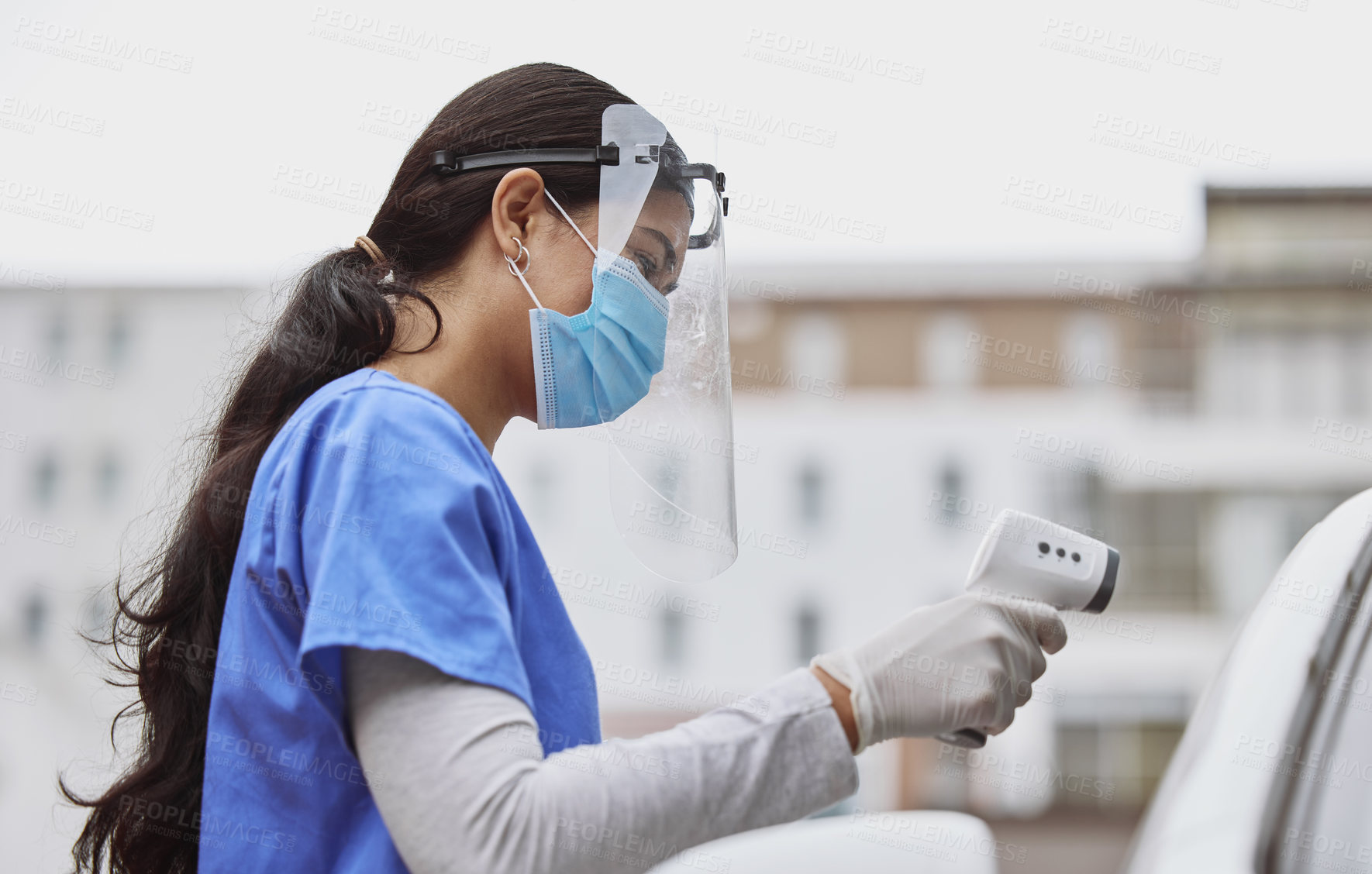 Buy stock photo Shot of a young healthcare worker taking a patient's temperature at a drive through vaccination site