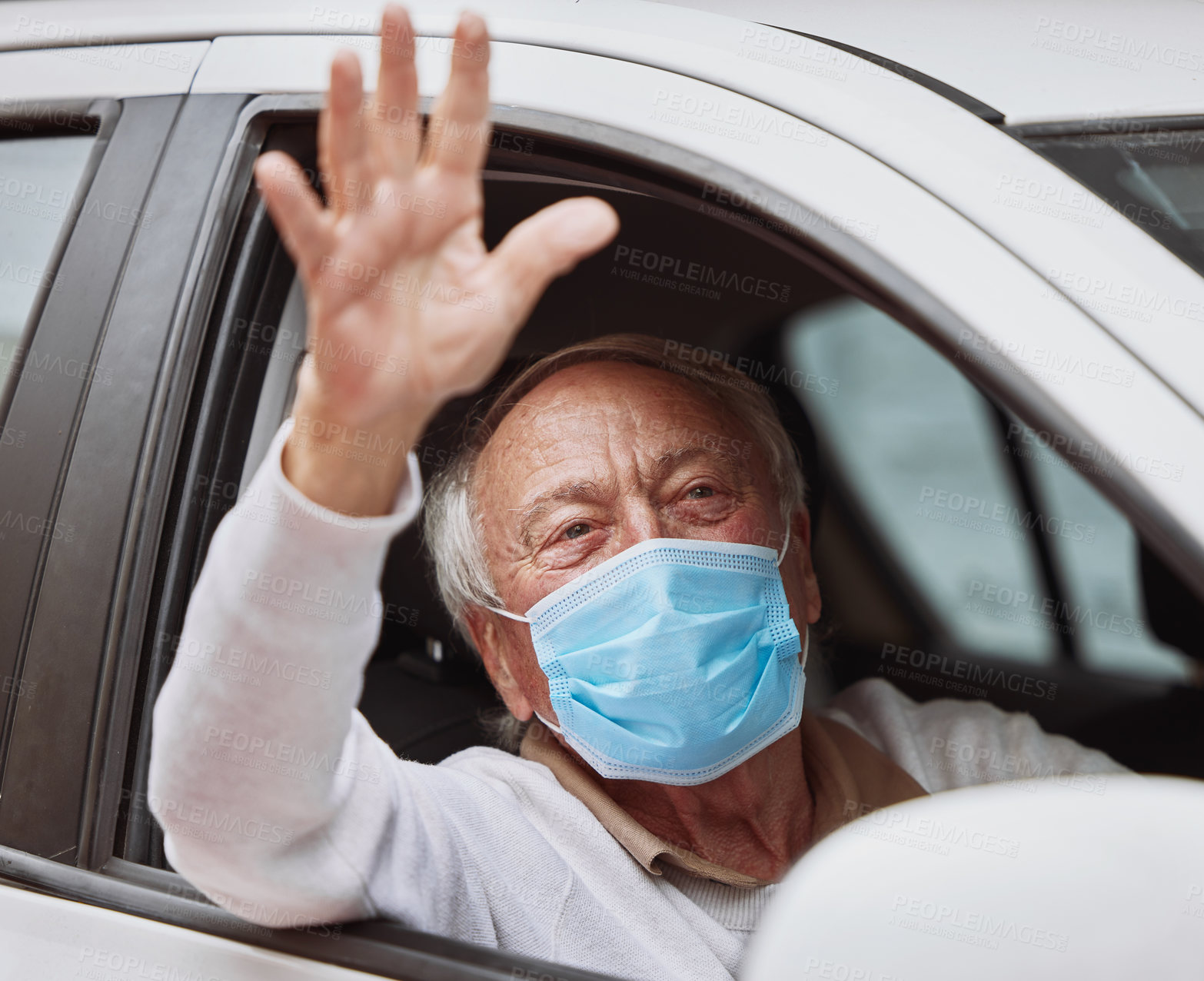 Buy stock photo Shot of a senior man waving while sitting in his car at a drive through vaccination site