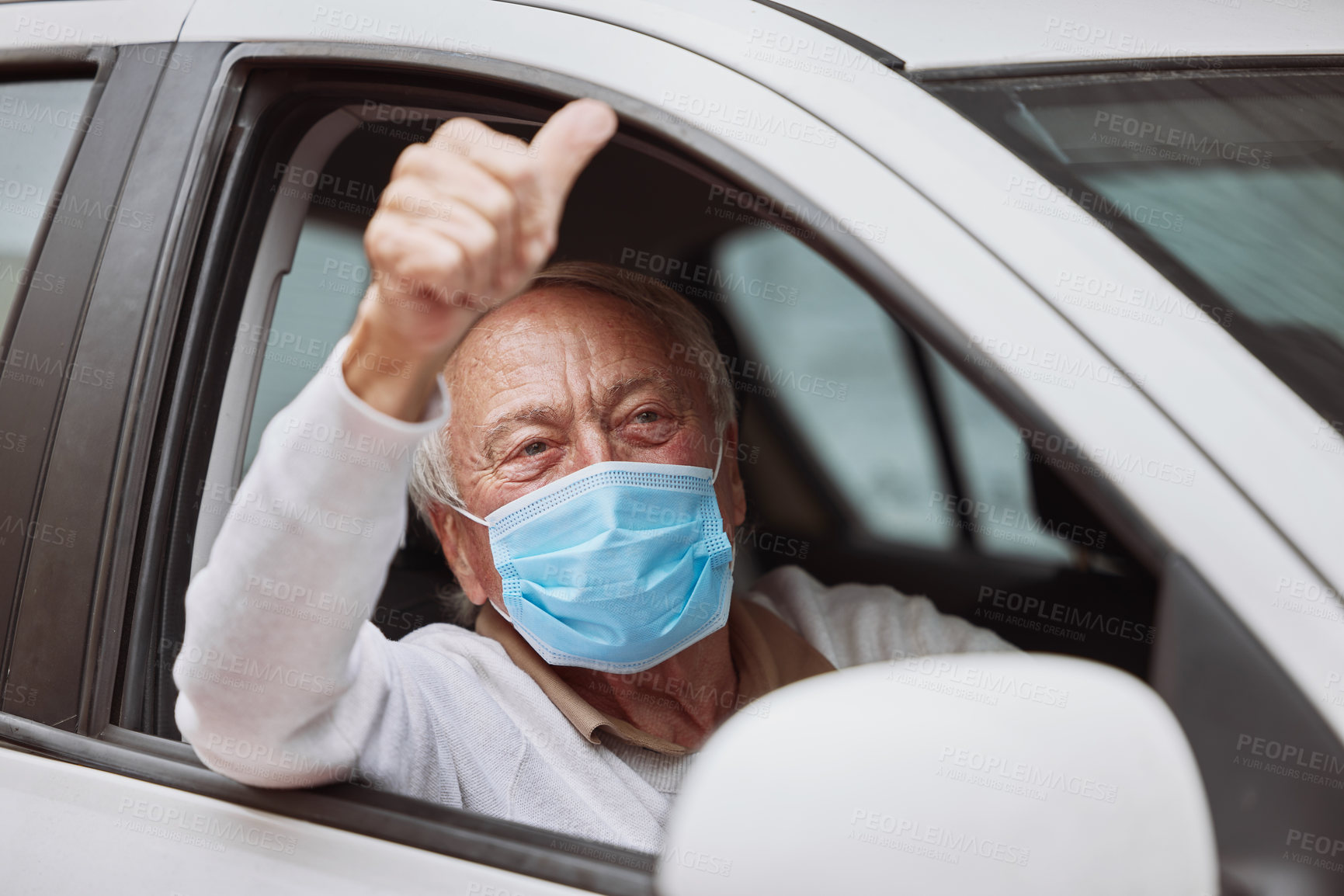 Buy stock photo Shot of a senior man showing a thumbs up in his car at a drive through vaccination site
