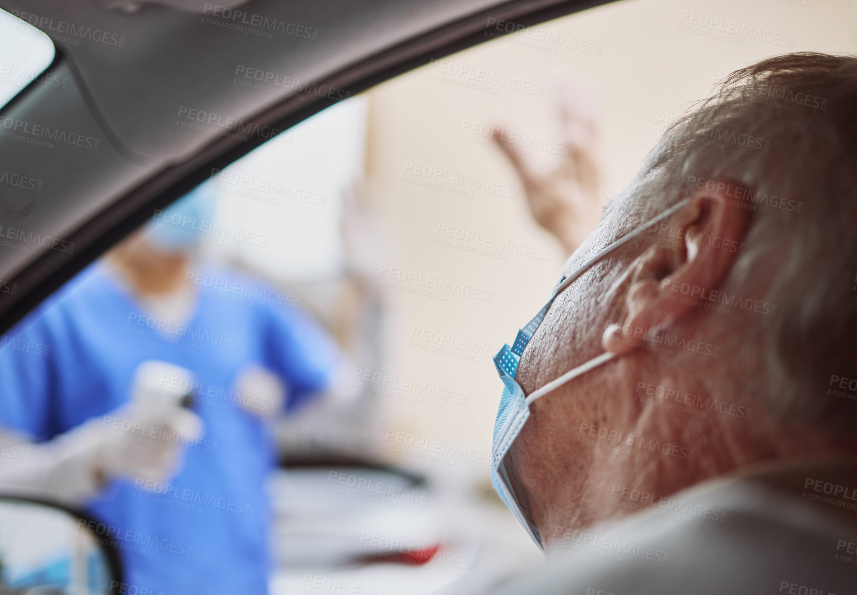 Buy stock photo Shot of a senior man waving at a healthcare worker while in his car at a drive through vaccination site