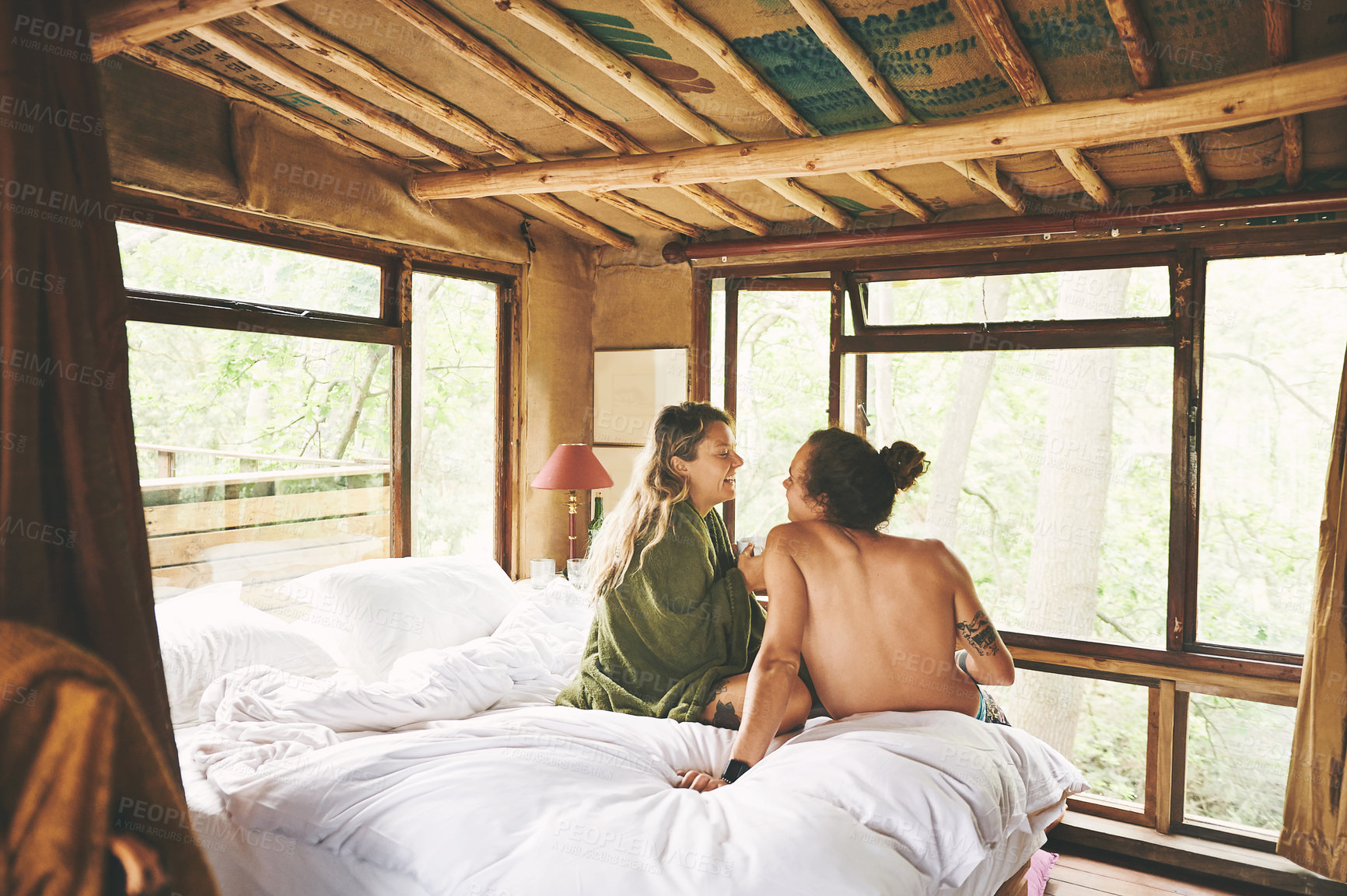 Buy stock photo Shot of a young couple relaxing on a bed while on holiday in a cabin