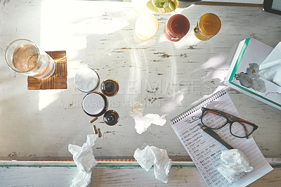 Buy stock photo High angle shot of medication, tissues a notepad and glasses on a table at home
