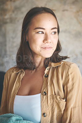 Buy stock photo Shot of a young woman holding freshly washed laundry at home