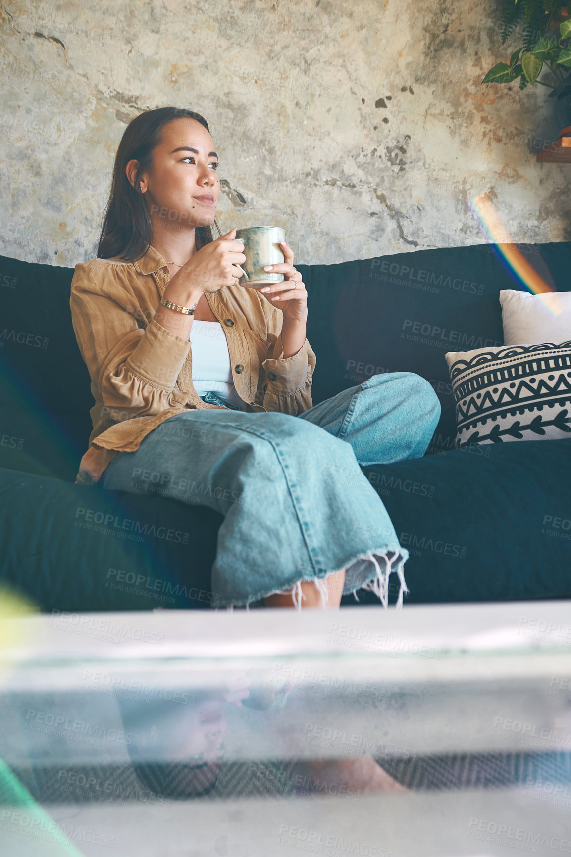 Buy stock photo Shot of a young woman having coffee and relaxing on the sofa at home