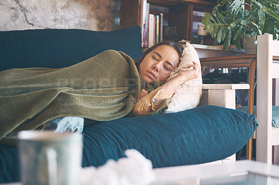 Buy stock photo Shot of a young woman resting under a blanket on the sofa at home