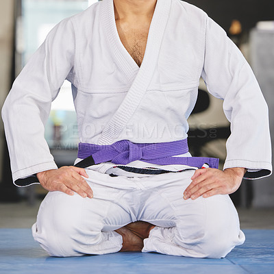 Buy stock photo Martial arts, fitness and man kneeling in gym for training, uniform or professional fighting sport. Health, wellness and Brazilian jiu jitsu athlete in dojo with gi, ground exercise or sitting on mat