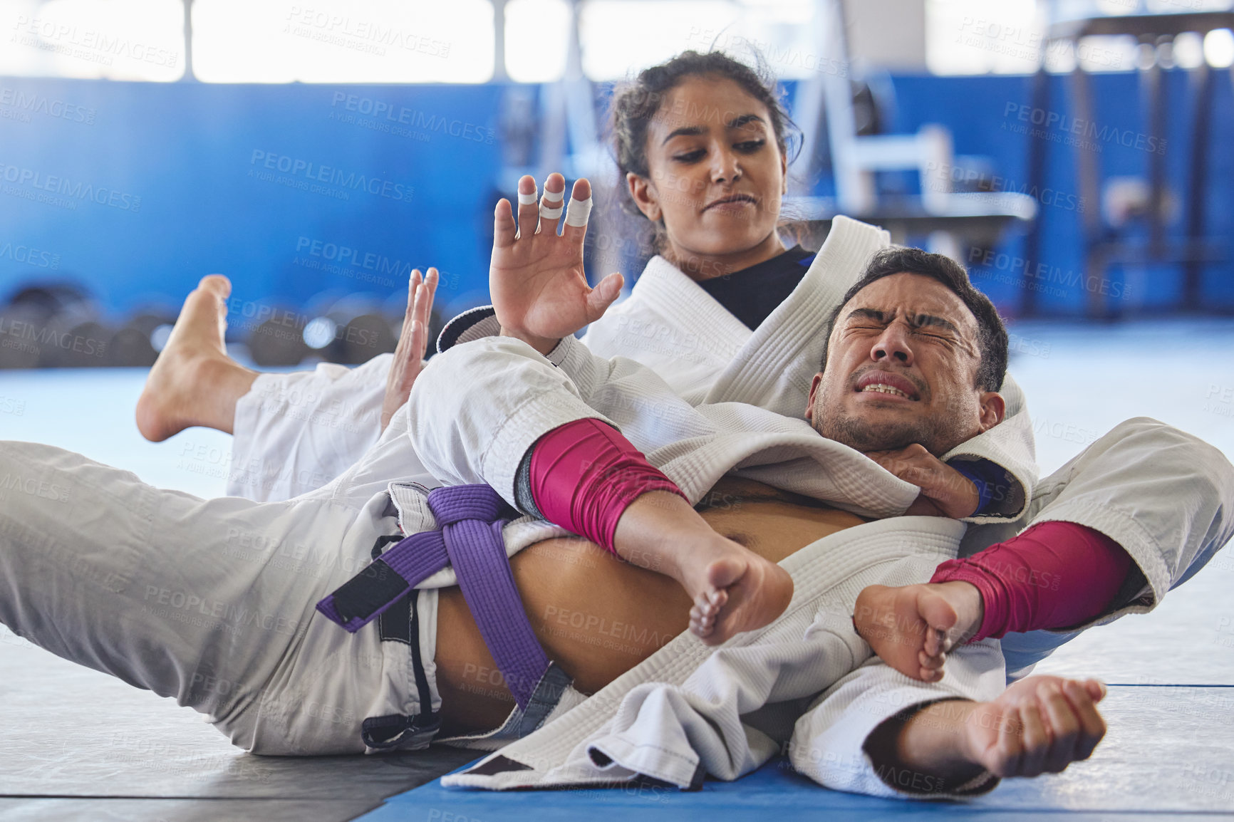 Buy stock photo Cropped shot of two young martial artists practicing jiu jitsu in the gym