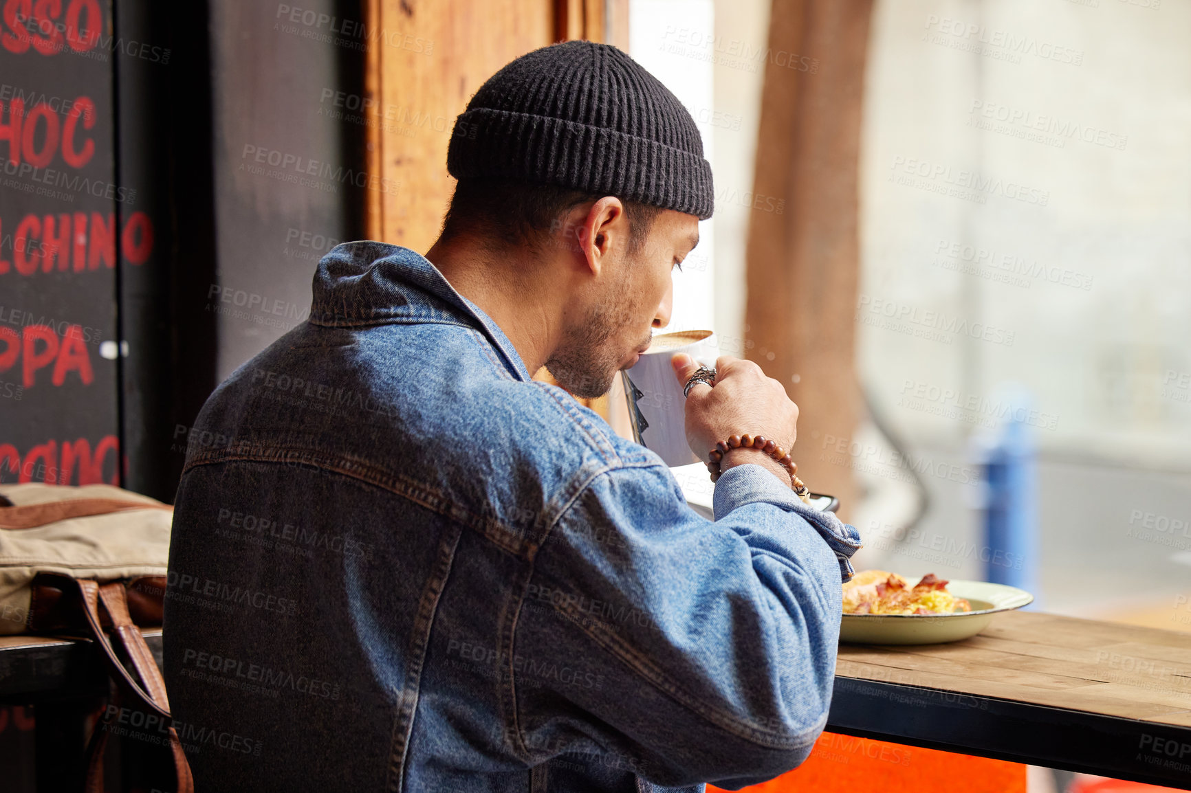 Buy stock photo Man, coffee shop and drinking at morning with breakfast in a restaurant with hot cappuccino. Cafe, brunch and table with hungry traveler with tea by the window of a bistro with food and latte