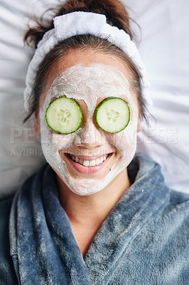 Buy stock photo Shot of a young woman lying down with a beauty facial treatment on her face