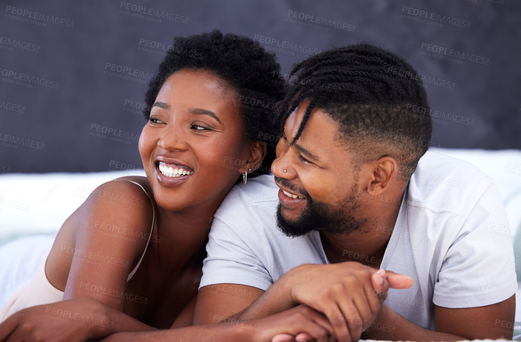 Buy stock photo Shot of a young couple being intimate in bed at home