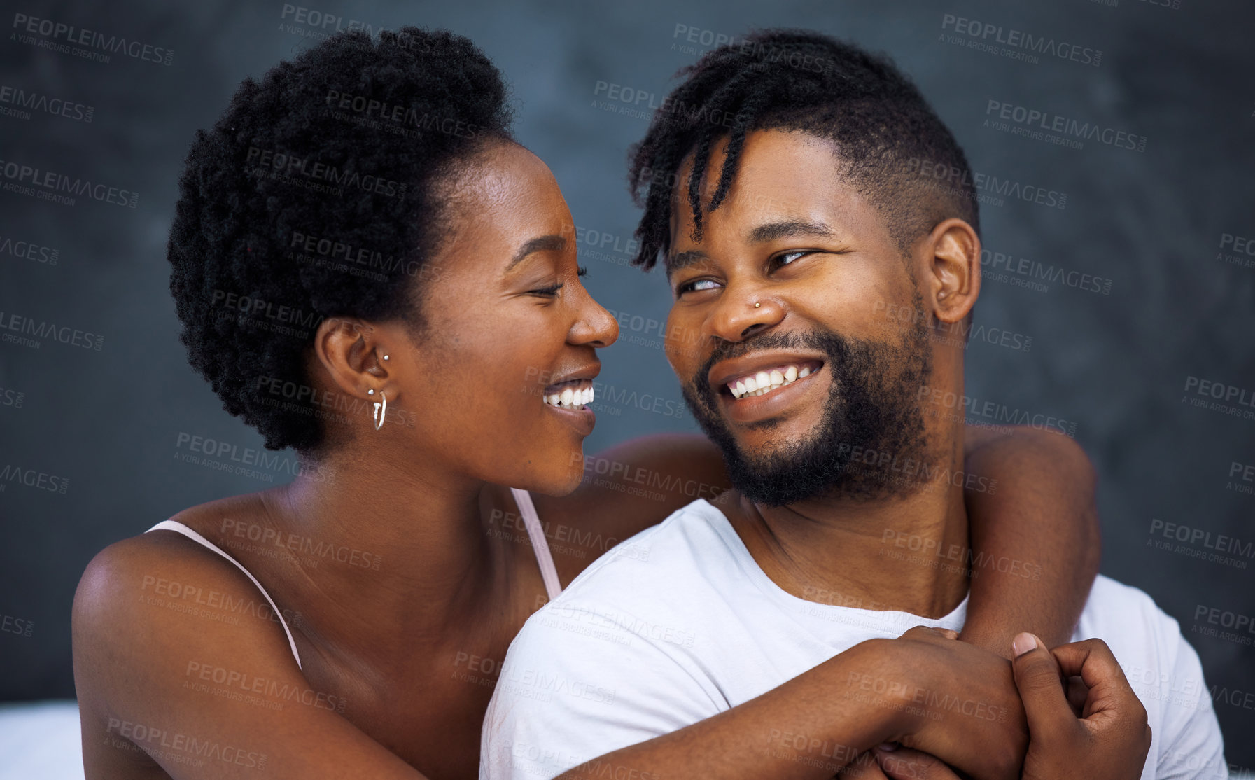 Buy stock photo Happy couple, hug and embrace in bedroom for romance, love and connection as partner in relationship. African woman and man for support with smile, intimacy and joy in marriage for bonding or trust