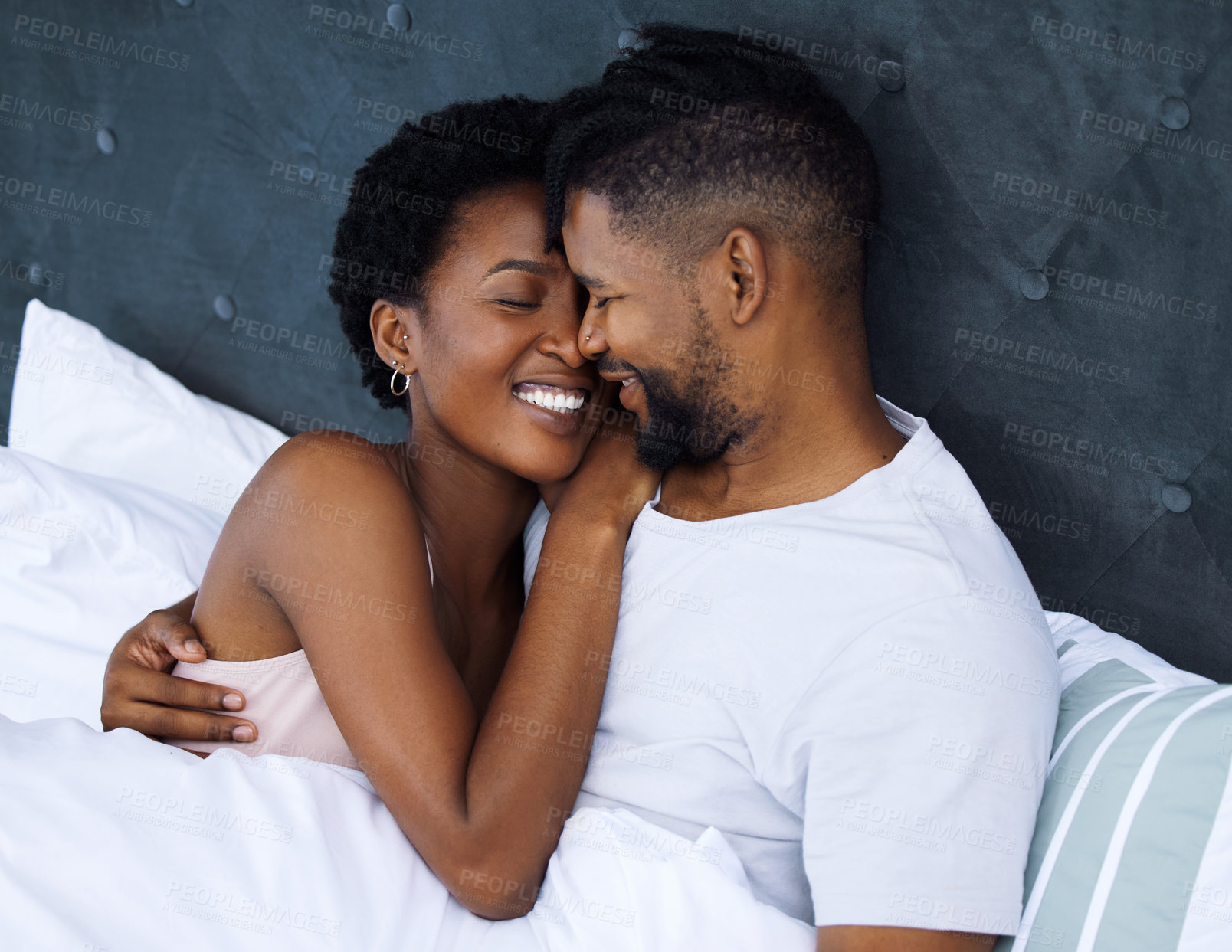 Buy stock photo Black couple and embrace or hug in bed with smile for love, romantic and care on Saturday morning. Relaxing, dating and relationship with passion for partner with comfort, waking up and rest in home