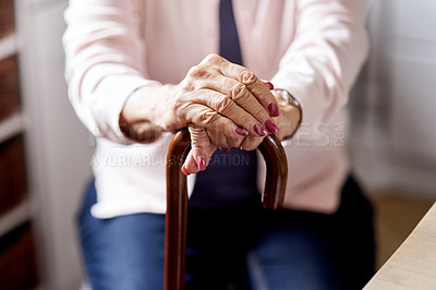 Buy stock photo Closeup shot of an unrecognizable elderly woman holding onto a cane at home