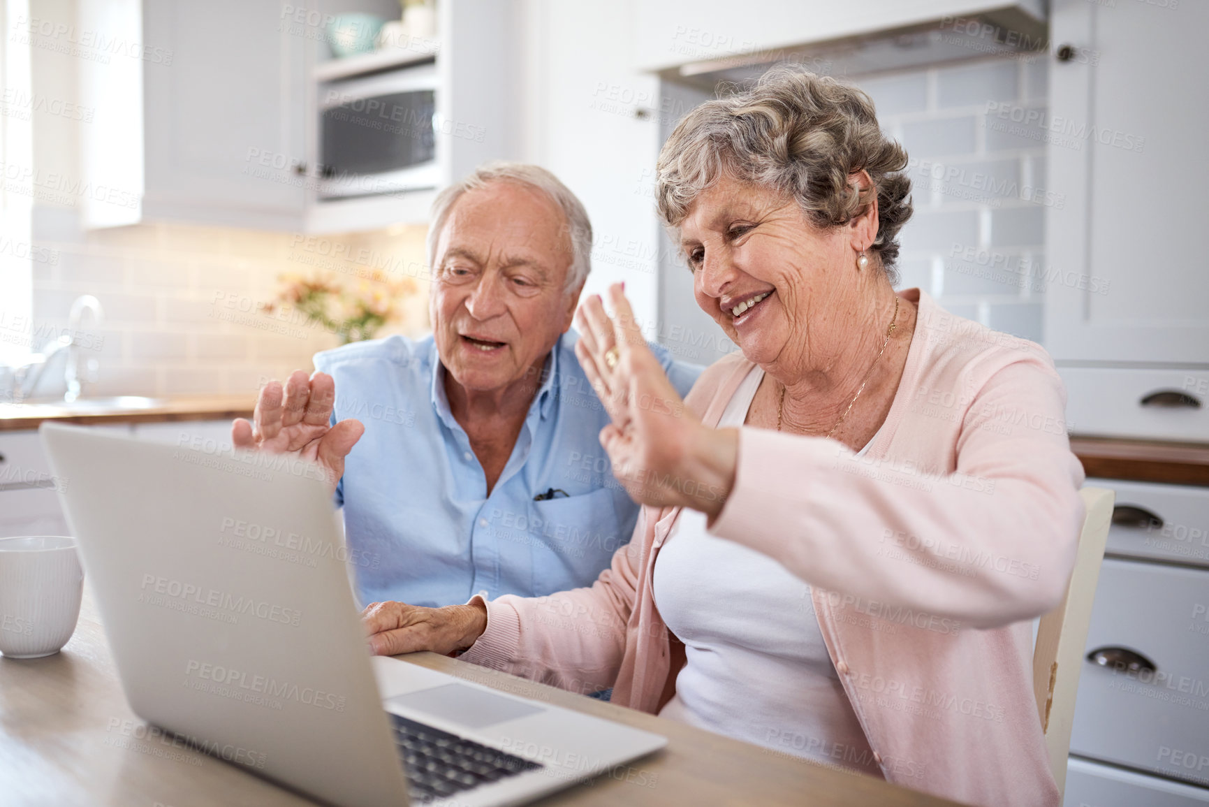 Buy stock photo Shot of an elderly couple using a laptop together on a video call at home