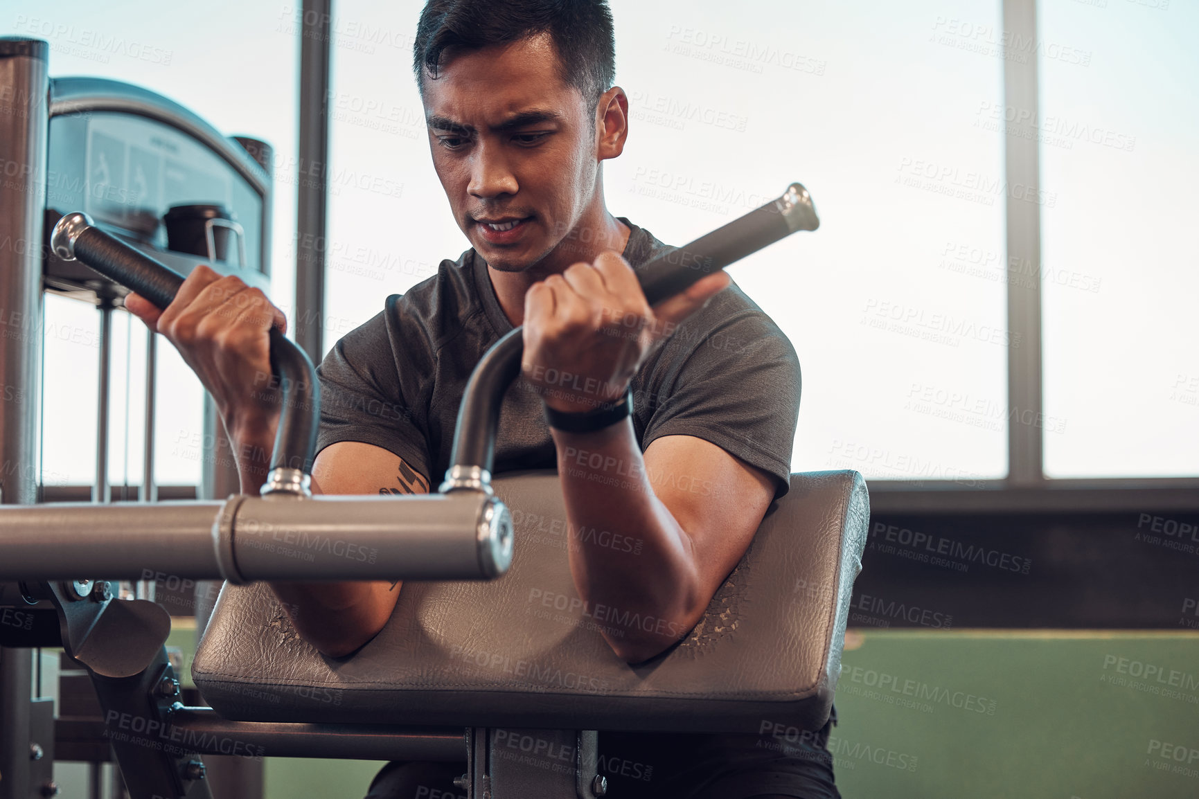 Buy stock photo Shot of a young man working out in the gym