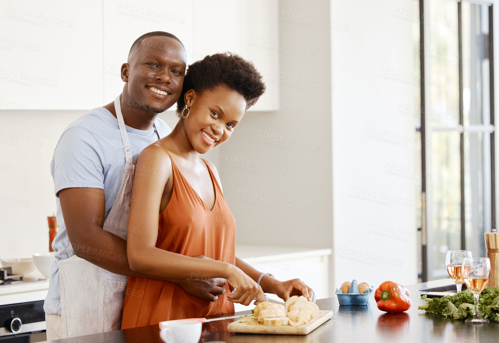 Buy stock photo Portrait, hug and black couple in a kitchen for cooking, meal and bonding in their home together. Food, face and happy woman and man with love preparing dinner with bread, nutrition and vegetable