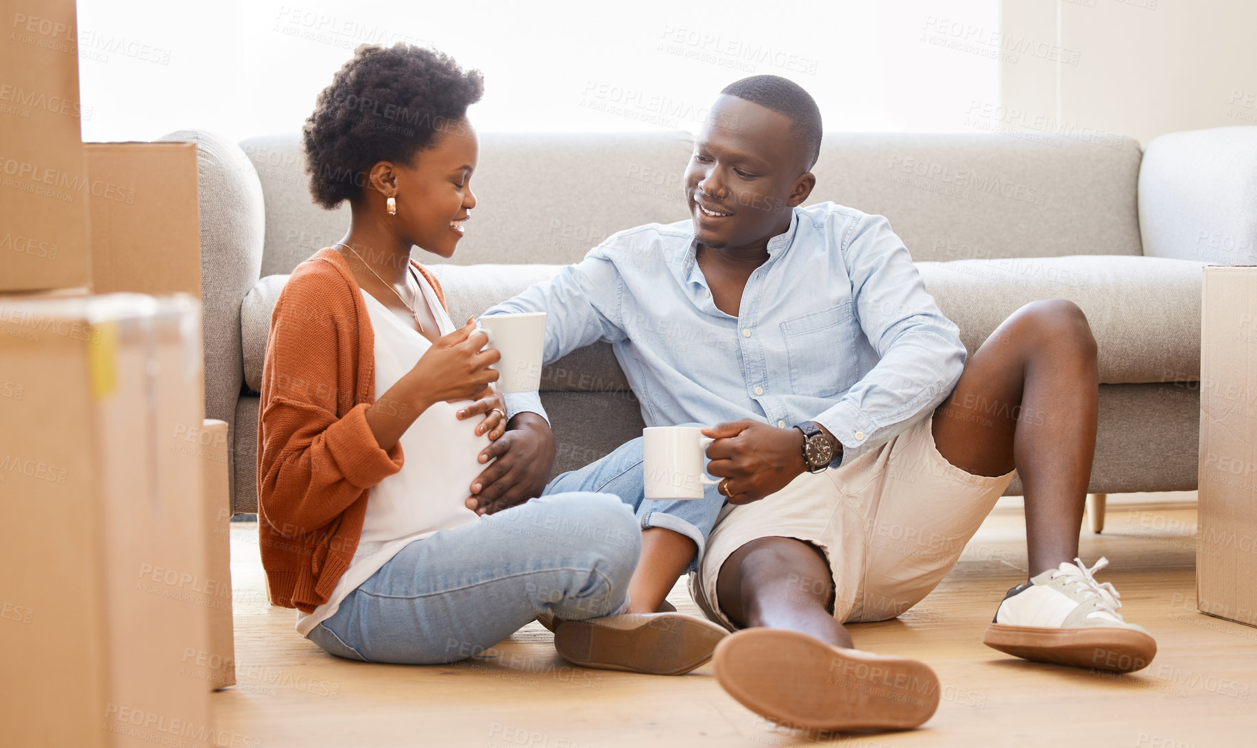 Buy stock photo African, couple and boxes with tea in lounge for moving, house and relocation on couch in living room. Woman, man and pregnancy as happy in packing for apartment, new home or property as young people