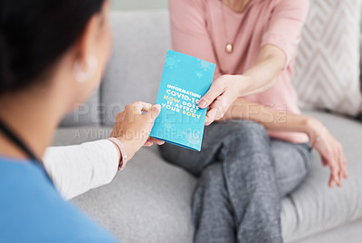 Buy stock photo Shot of a female nurse giving her patient a Covid-19 information pamphlet