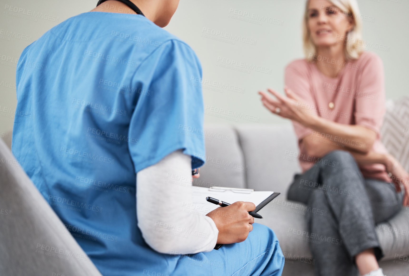 Buy stock photo Shot of a female nurse sitting with a clipboard while having a consultation with a patient