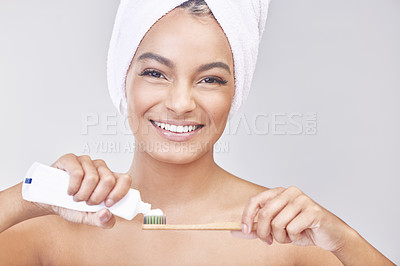 Buy stock photo Studio shot of a beautiful young woman brushing her teeth against a grey background