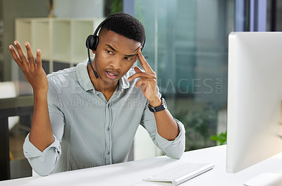 Buy stock photo Shot of a young man using a headset and looking stressed in a modern office