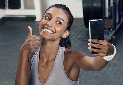 Buy stock photo Woman, thumbs up and selfie on phone in gym for social media post or wellness blog in training. Happy, active and female person with mobile for sign of success workout or fitness session for health