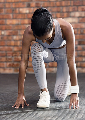 Buy stock photo Shot of a sporty young woman in starting position in a gym