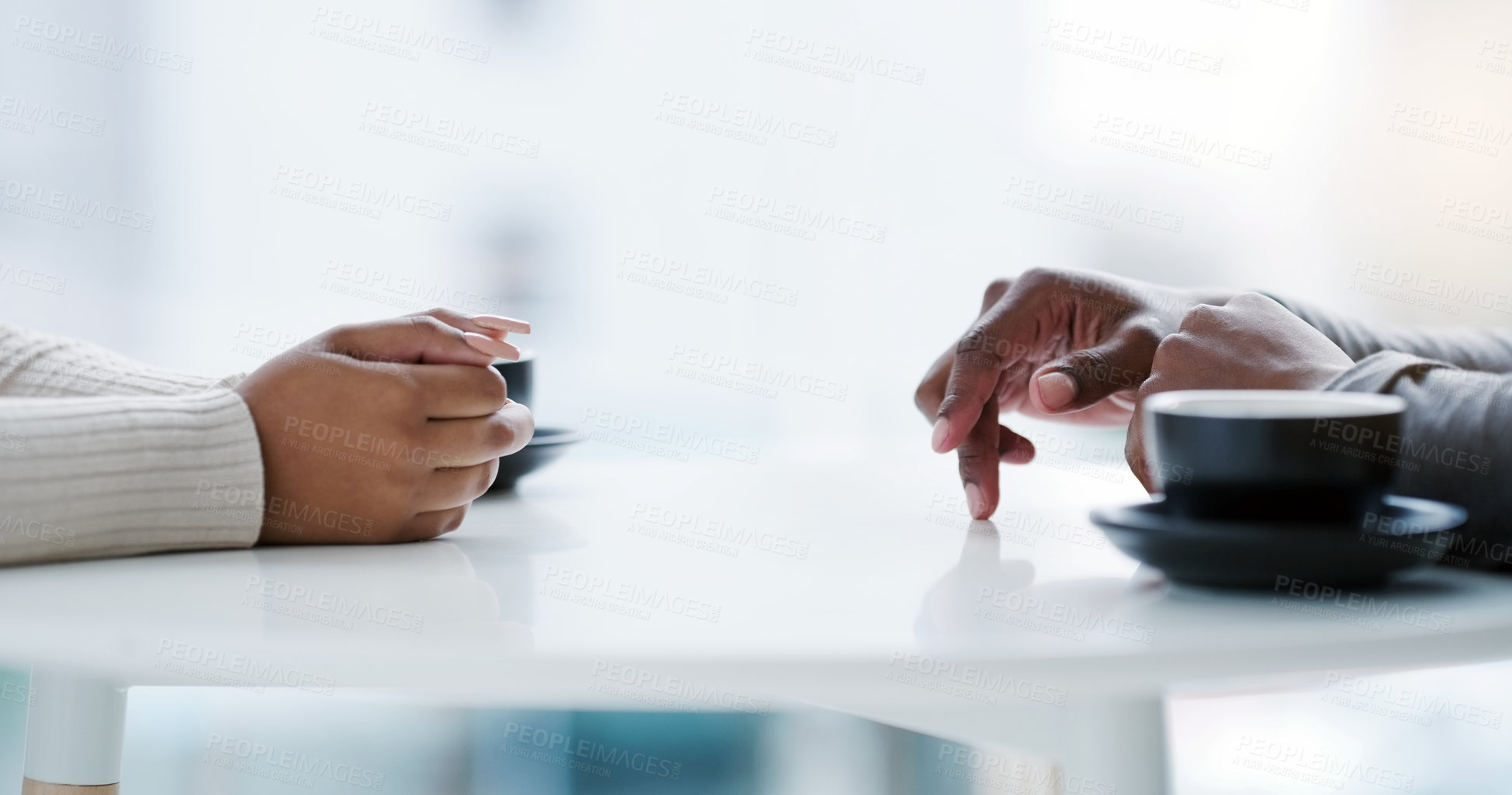 Buy stock photo Cropped shot of an unrecognizable couple sitting together at a table