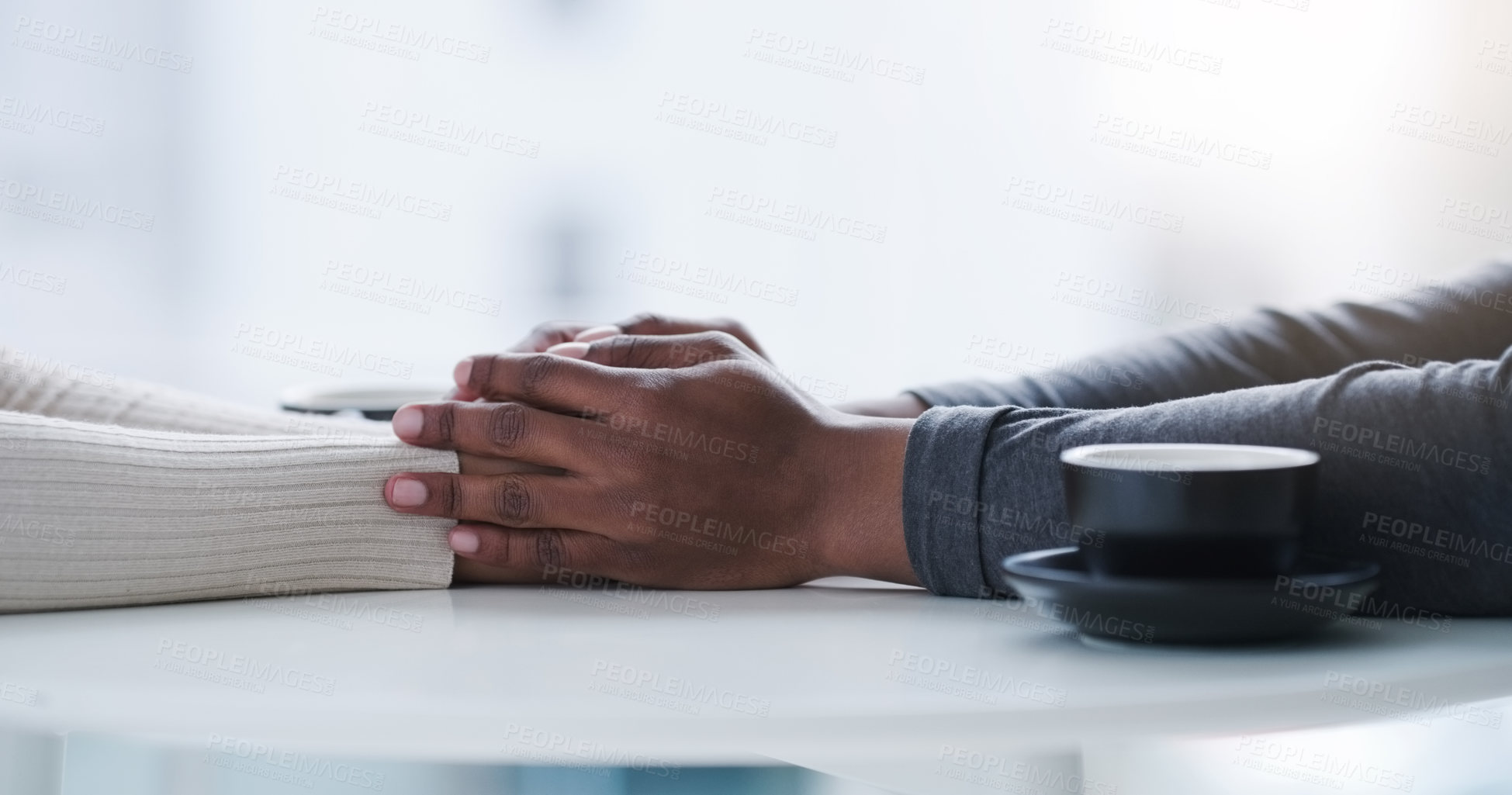 Buy stock photo Shot of an unrecognizable couple holding hands while sitting at a table