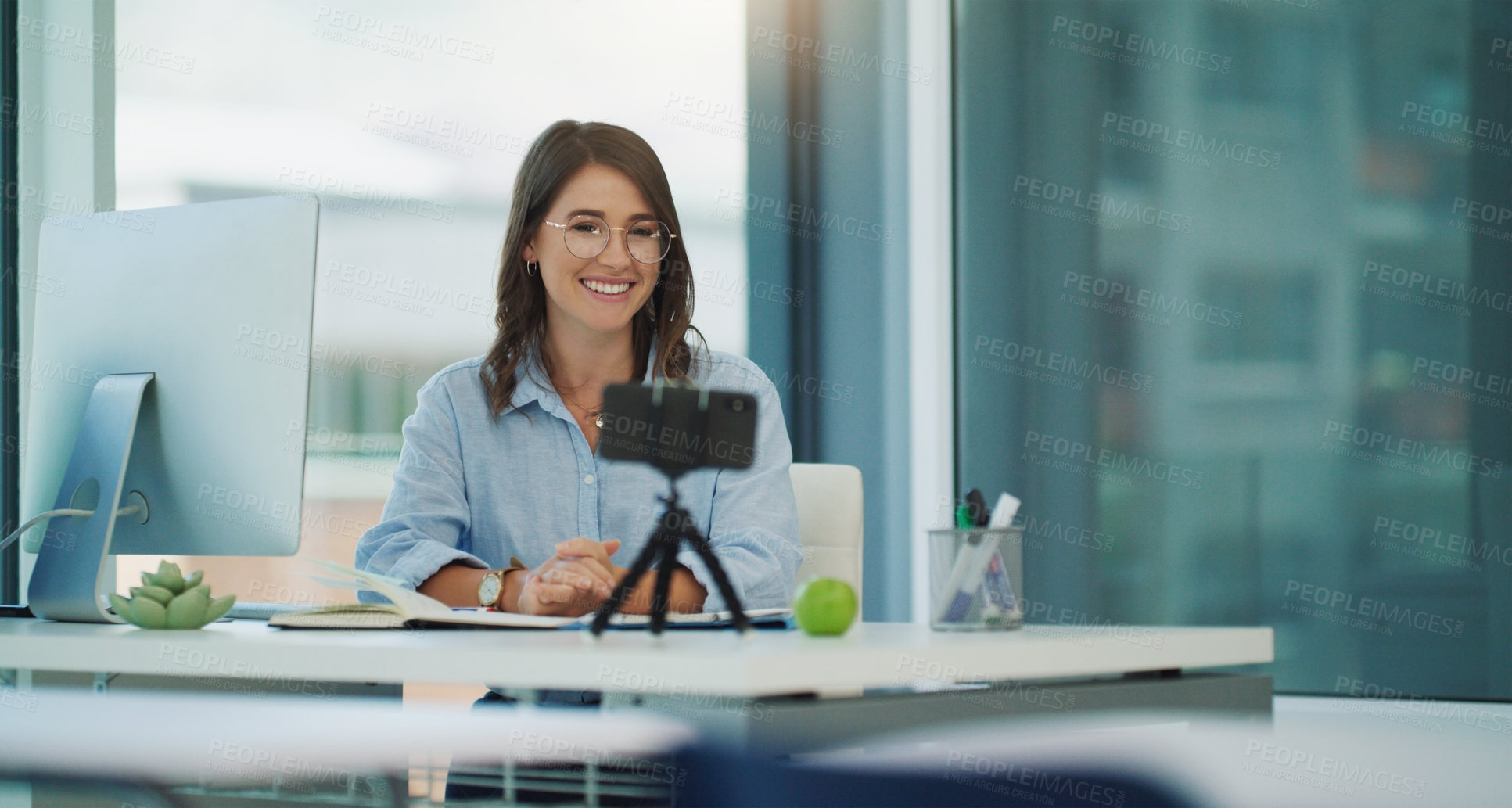 Buy stock photo Shot of a beautiful professor sitting while using her cellphone at her desk