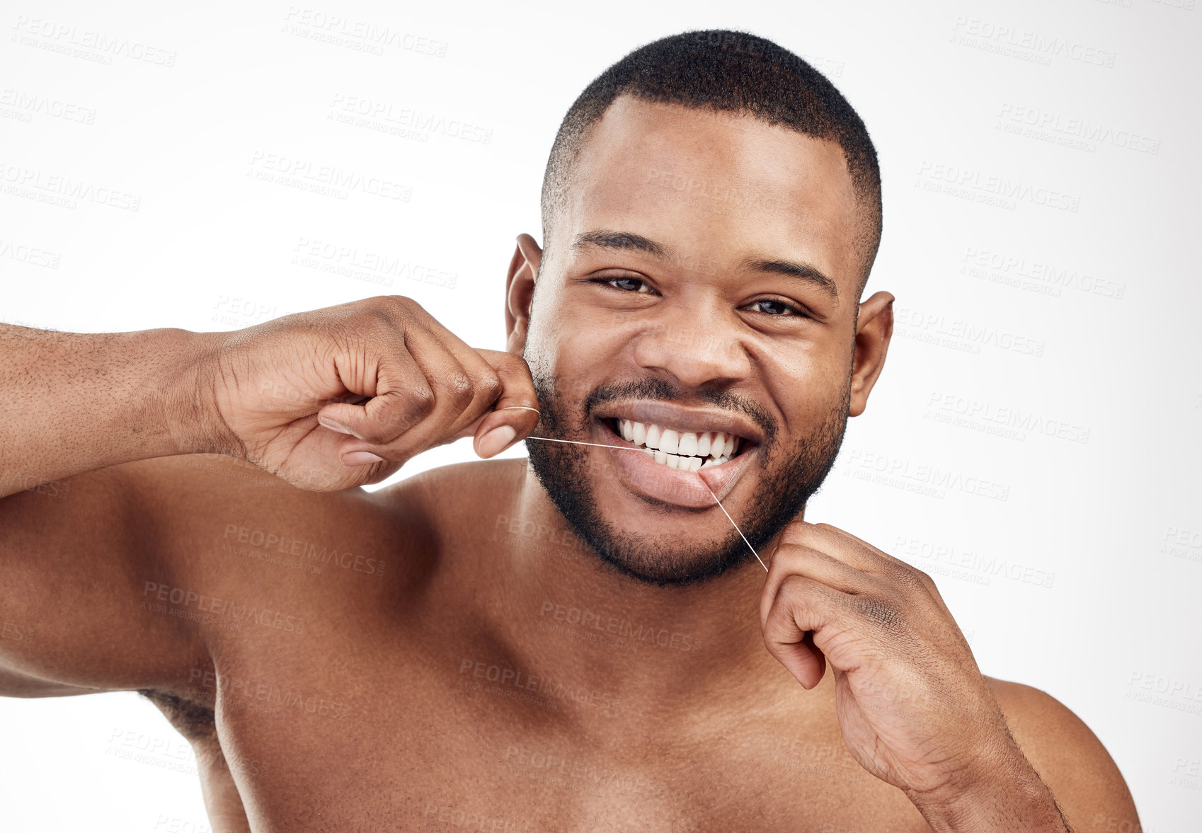 Buy stock photo Studio portrait of a handsome young man flossing his teeth against a white background