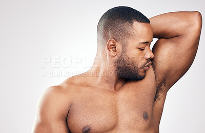 Buy stock photo Studio shot of a handsome young man smelling his armpit against a white background