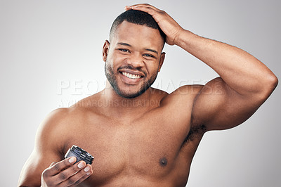 Buy stock photo Studio portrait of a handsome young man styling his hair against a white background