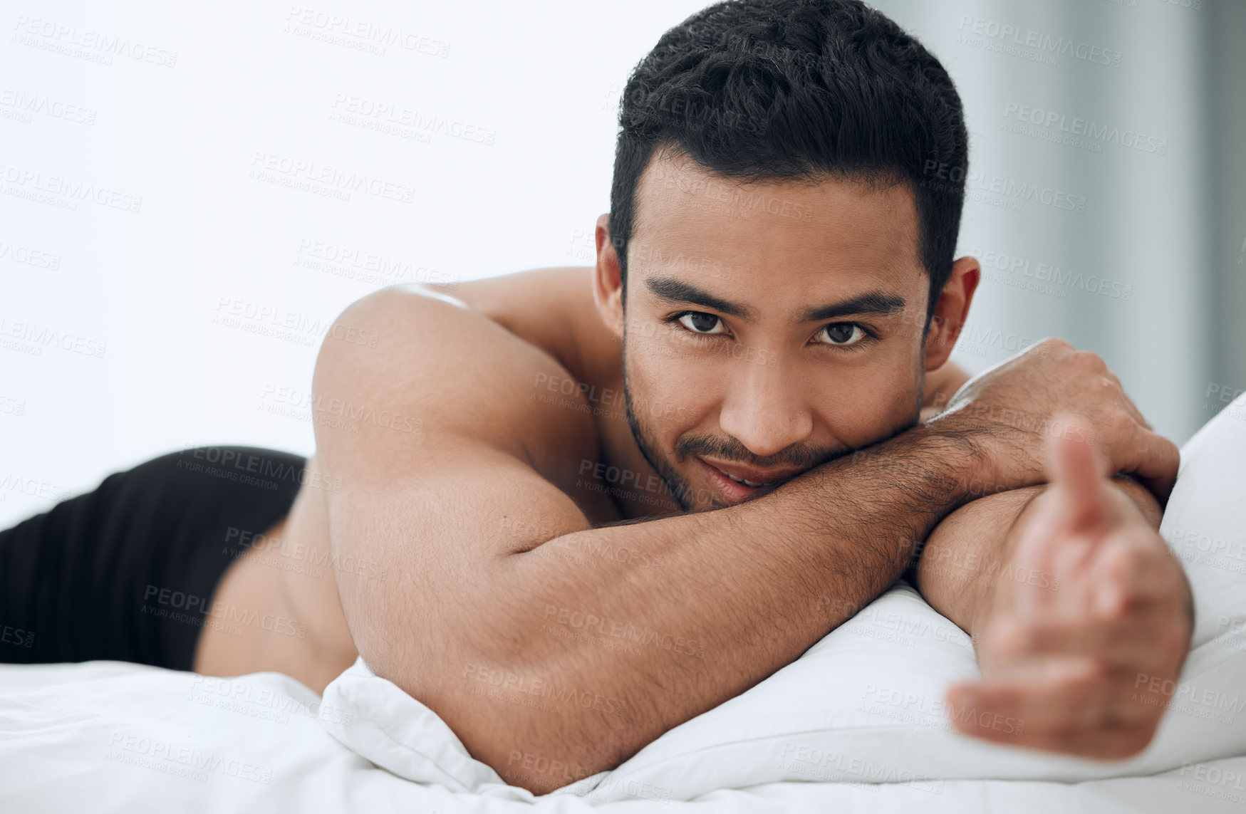 Buy stock photo Happy, man and hand for welcome to bed in morning with blankets and pillows for romance or intimacy at home. Asian male person and model with smile, confidence and sexy greeting or gesture in bedroom