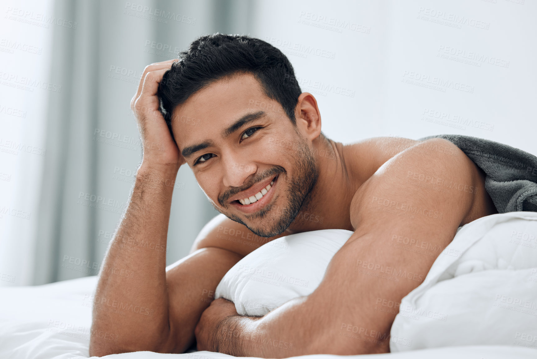 Buy stock photo Shot of a handsome young man lying on his bed