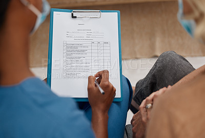 Buy stock photo Shot of a doctor filling out a questionnaire during a consultation with a senior woman at home