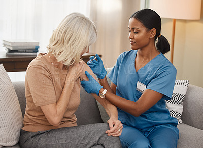 Buy stock photo Shot of a doctor giving a senior woman an injection at home