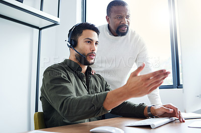 Buy stock photo Shot of a young male call center worker receiving direction from his boss