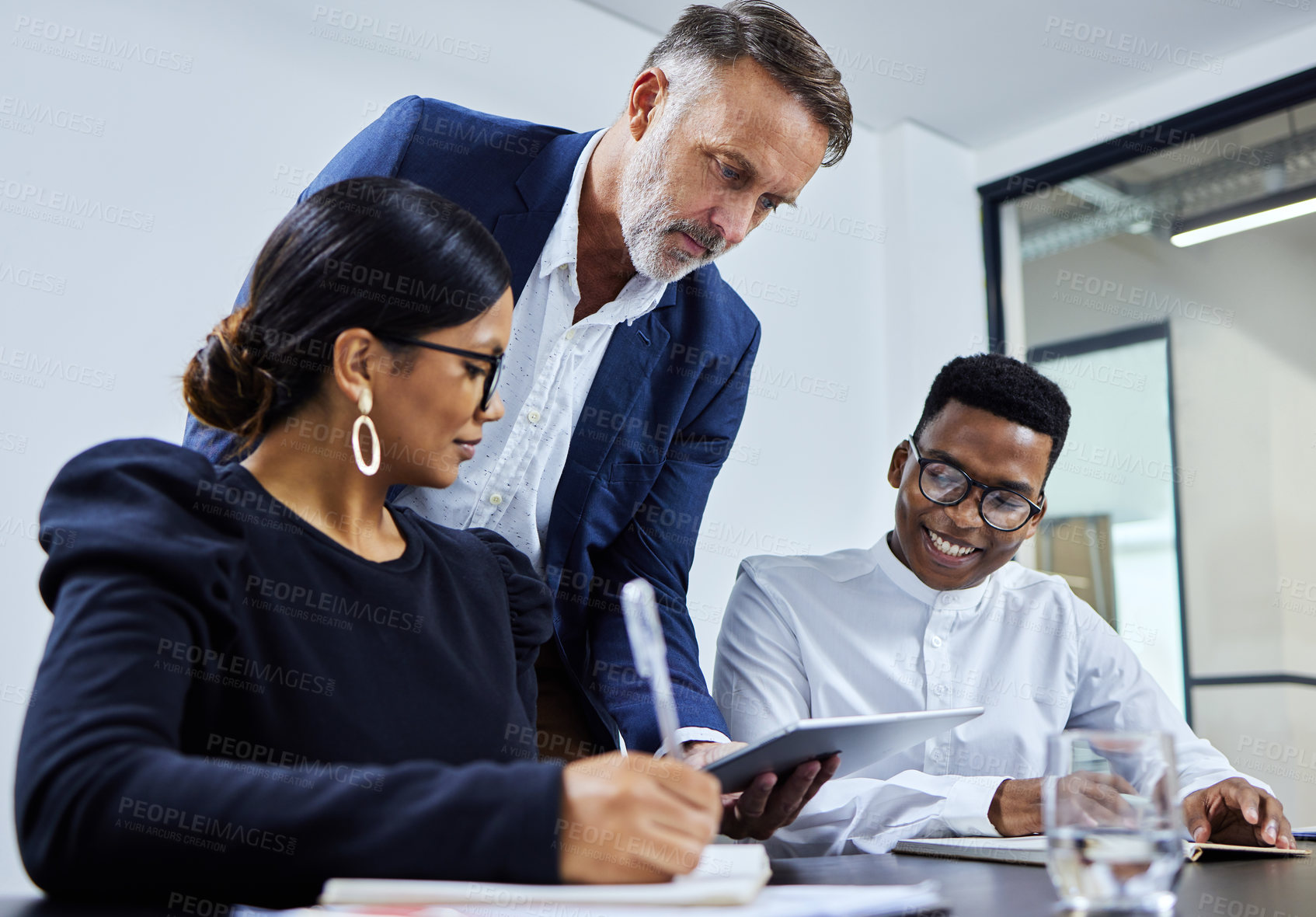 Buy stock photo Shot of a group of businesspeople using a digital tablet together in an office