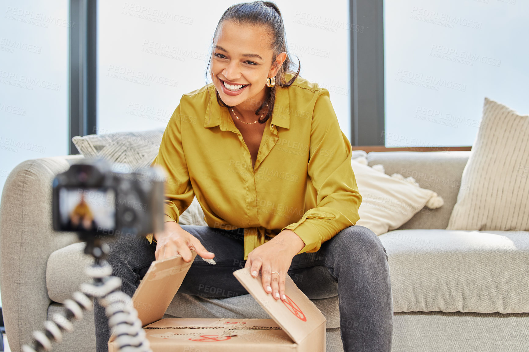 Buy stock photo Shot of a young woman recording a video for her vlog at home