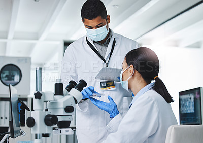 Buy stock photo Shot of two young researchers using a digital tablet in a laboratory