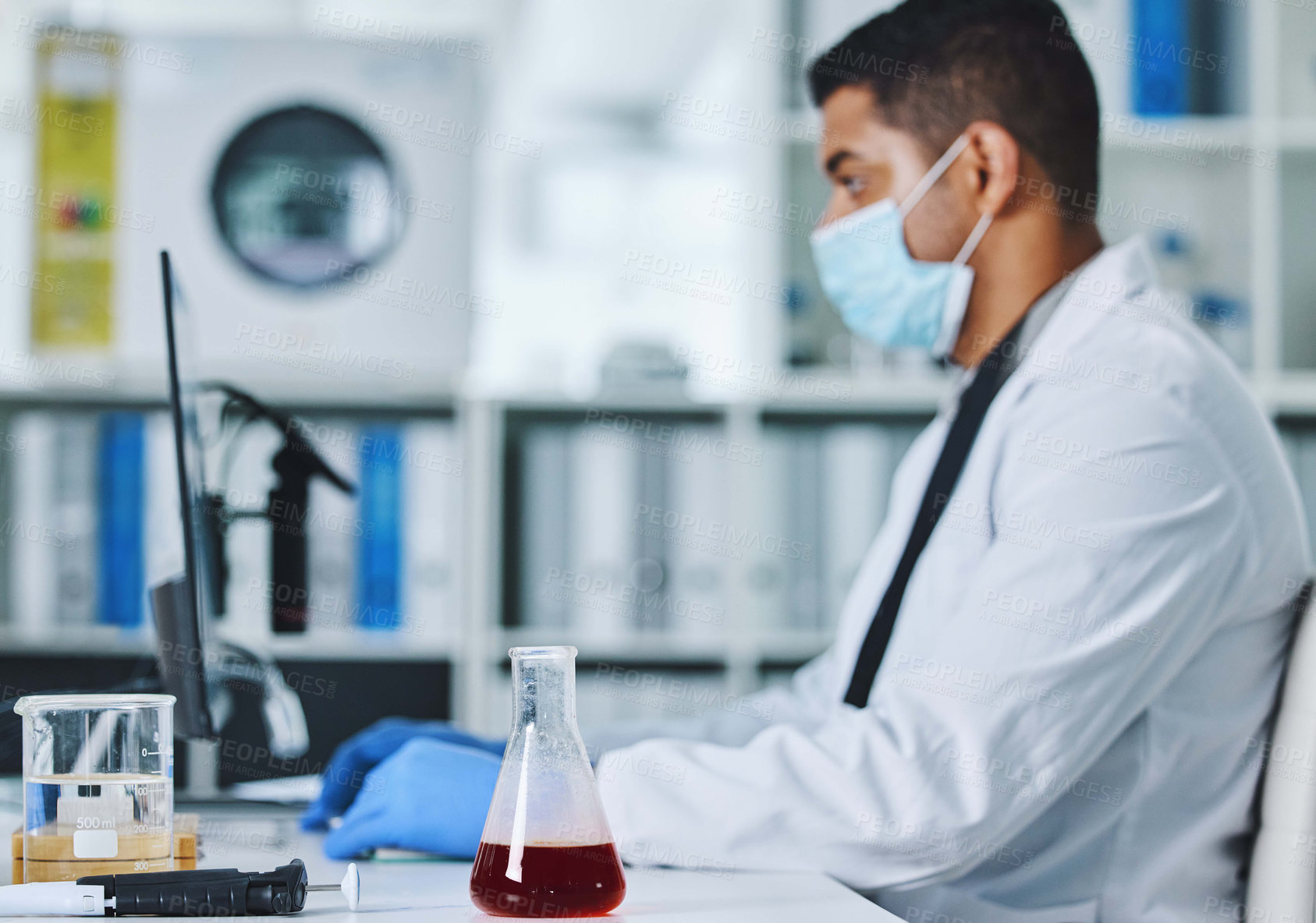 Buy stock photo Scientist man, computer and typing in lab for medical, pharmaceutical or covid research in face mask. Young male doctor, innovation and report on pc, check dna and science app for blood in laboratory