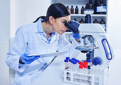 Buy stock photo Cropped shot of an attractive young female scientist working on a microscope in her lab